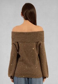 Maglione marrone a spalle scoperte con texture scintillante, colletto a costine e maniche lunghe, caratterizzato da una vestibilità rilassata e sottili accenti di glitter.