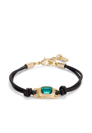 Pulsera de doble cordón negra con cierre de oro y un engaste rectangular de oro que sostiene una gema facetada de color azul verdoso en el centro.