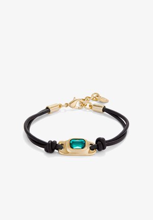 Pulsera de doble cordón negra con cierre de oro y un engaste rectangular de oro que sostiene una gema facetada de color azul verdoso en el centro.