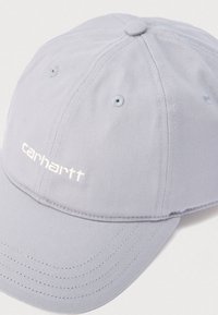 Ανοιχτό γκρι καπέλο μπέιζμπολ Carhartt με ραμμένα πάνελ, οπές αερισμού και κυρτή γείσο σε λευκό φόντο.