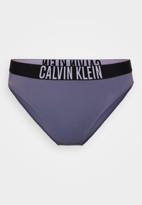Ženske brief hlačke Calvin Klein v svetlo vijolični barvi z rebrasto teksturo in črnim elastičnim pasom, ki nosi ime blagovne znamke v belem tisku.