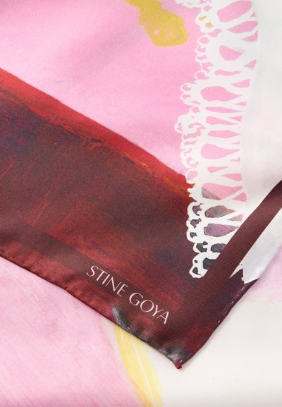 Hodvábna šatka s výrazným abstraktným dizajnom v ružovej a červenej farbe, zdobená zložitou bielou čipkou pozdĺž okraja a hnedým lemom s logom značky.