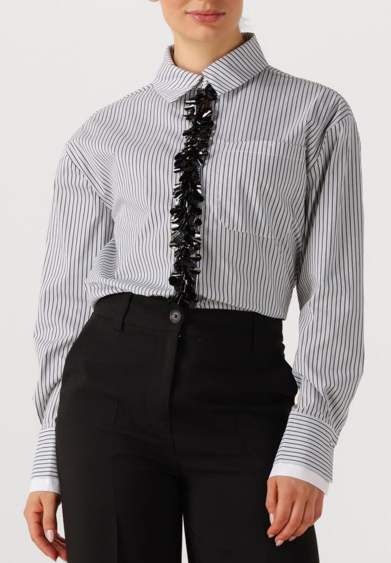 Wit gestreepte lange mouwen shirt met een gerimpelde zwarte accent over het midden, met een klassieke kraag en een voorzak.
