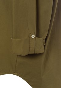 Tessuto della camicia verde oliva con una trama liscia. Presenta una manica arrotolata, dettaglio dei bottoni e un orlo curvo per una vestibilità rilassata.