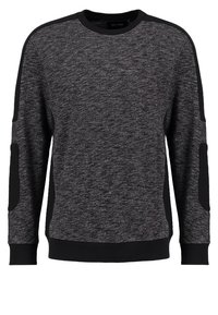Sweatshirt gris foncé en tissu texturé, présentant des accents noirs aux épaules et aux coudes, des poignets et une taille côtelés.