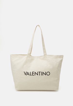 Tygkasse i ljusbeige med två långa handtag, med en framträdande svart "VALENTINO"-logotyp tryckt på framsidan.