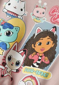 Personajes de dibujos animados que incluyen a una niña con cabello rizado y orejas de gato, gatos coloridos y el texto "¡PURR-ÍFICO!" sobre un fondo rosa claro.