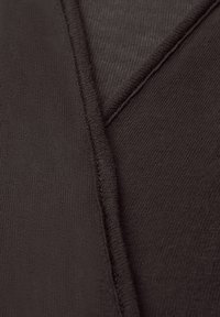 Primer plano de tela marrón oscuro con costuras visibles y detalles de costura doblada.