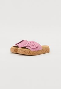 Infradito rosa con suola in sughero. La parte superiore è realizzata in morbido materiale scamosciato e presenta una cintura arrotondata con un dettaglio logo in rilievo.