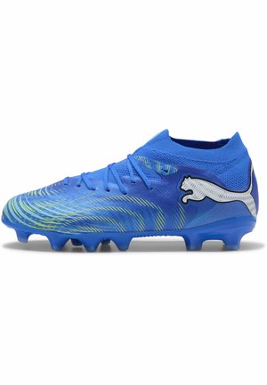 Chaussure de football Puma bleue avec des accents jaunes, une tige en maille haute, des lacets et des crampons moulés, vue de profil sur fond blanc.