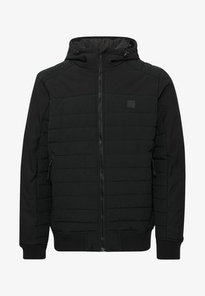 Melnā jaku ar odere un kapuci. Tam ir izšūta tekstūra uz ķermeņa, gludas piedurknes, kā arī riboti aproces un apakšmala.