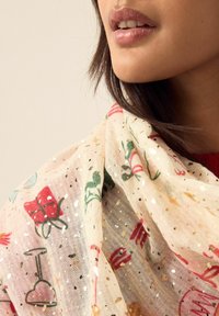 Lightweight, patterned scarf in sheer fabric featuring colorful drawings, gold accents, and a soft texture. Primarily white background.