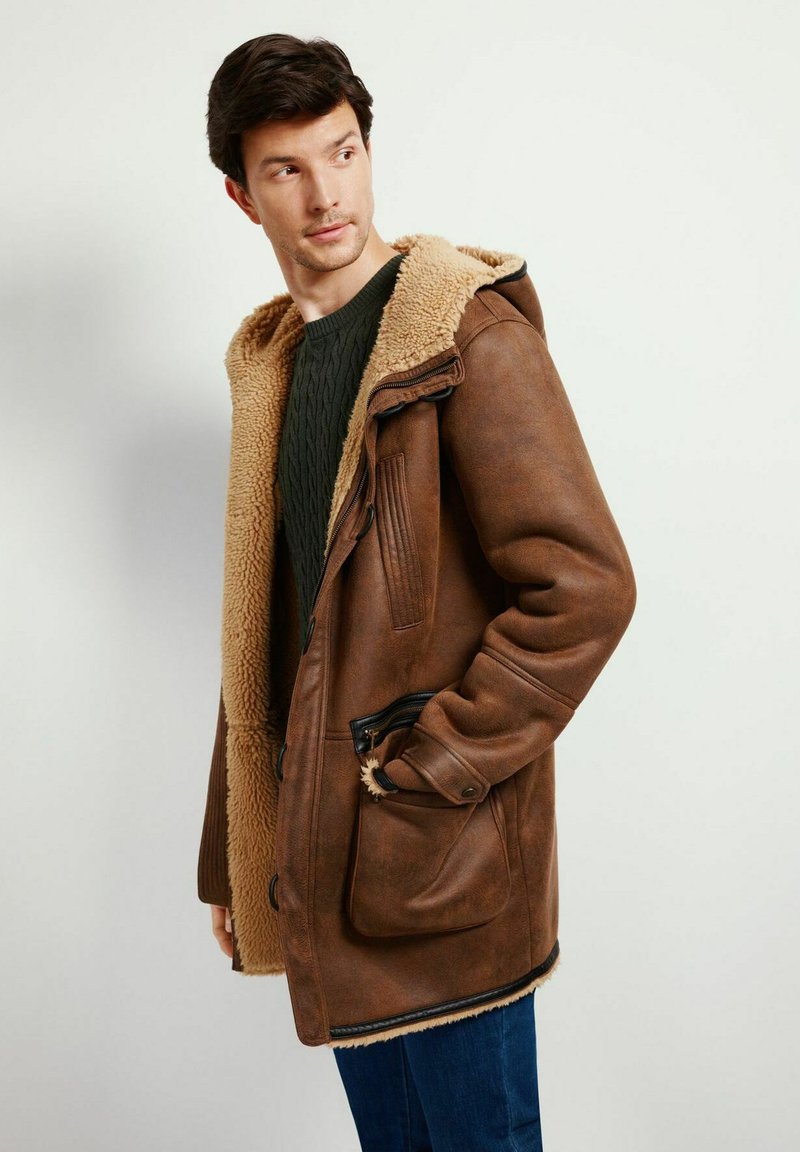 Braune Lederjacke mit einer mit Kunstfell gefütterten Kapuze und Kragen, ausgestattet mit Reißverschluss- und Knopfverschluss, Seitentaschen und strukturierten Ärmeln.