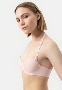 Reggiseno strapless rosa chiaro con tessuto liscio e spalline ricamate con motivi floreali. Caratterizzato da coppe sagomate e bordi senza cuciture per un aspetto elegante.