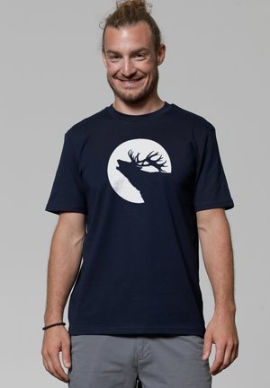 Navy T-shirt made of cotton, featuring a white silhouette of a stag against a full moon graphic on the front. Short sleeves and crew neck.