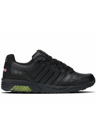 Schwarze Sportschuhe mit einem Obermaterial aus Leder und Synthetik, das strukturierte Akzente, ein gestreiftes Design und eine grüne transparente Sohle aufweist.