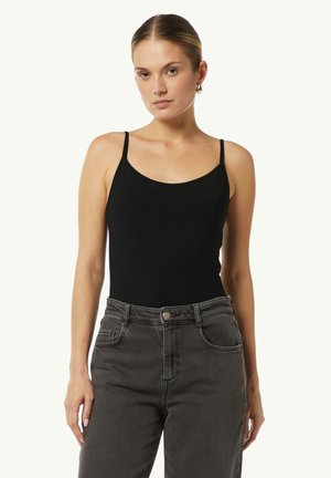 Black fitted tank top with thin straps, round neckline, and stretchy cotton blend fabric, paired with high-waisted dark gray jeans.