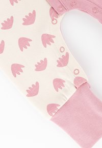 Cotton onesie featuring a cream base with pink handprint-like patterns, pink snap closure, and coordinating pink cuffs.
