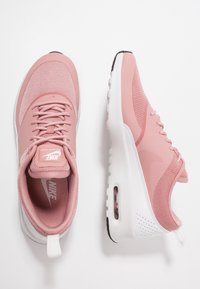 Zapatillas Nike Air Max de color rosa claro con parte superior de malla, cuello acolchado y entresuela blanca. Presenta amortiguación Air visible y acentos texturizados.