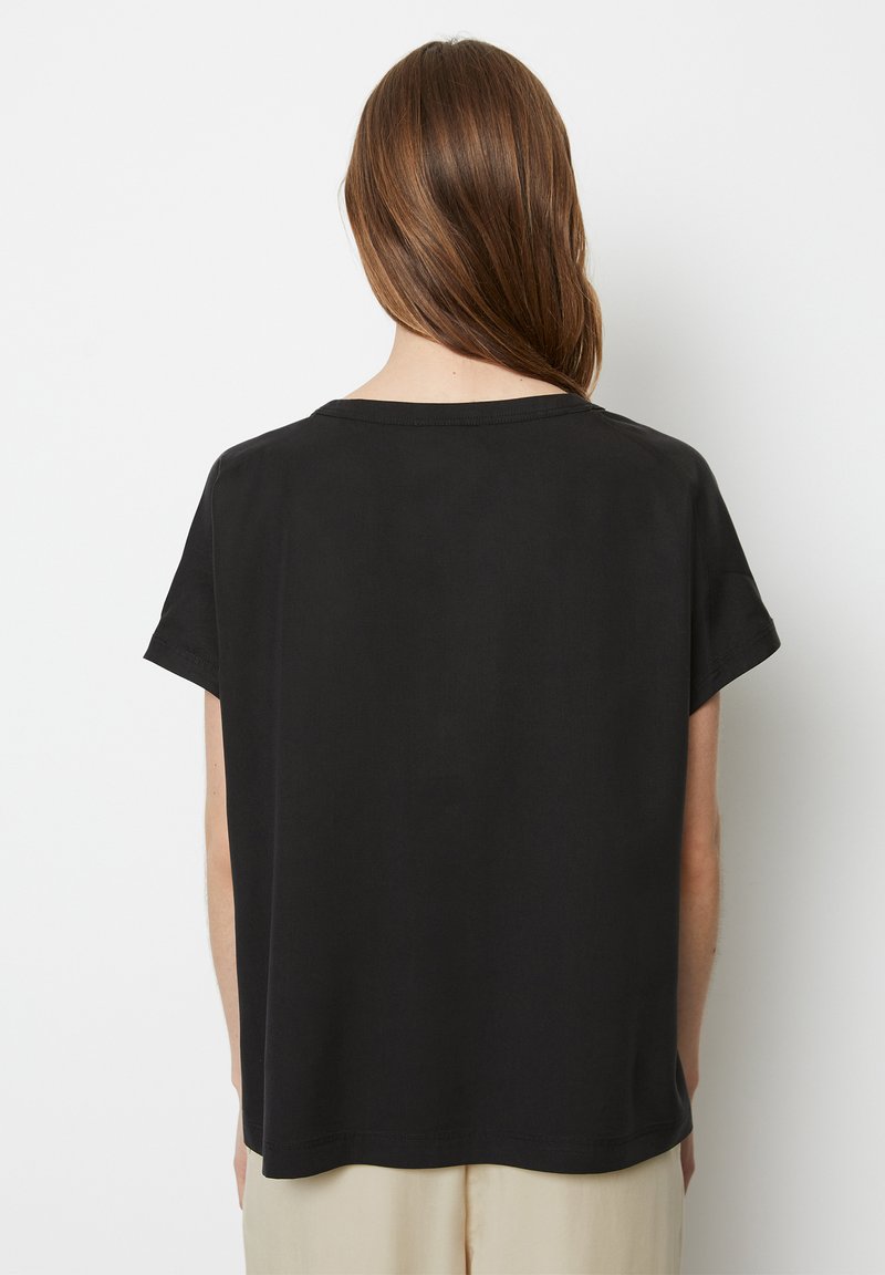 Sort kortærmet t-shirt med afslappet pasform, rund halsudskæring og glat tekstur. Den nederste kant er let buet for ekstra designdetalje.