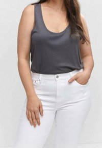 Top gris de tirantes hecho de una tela suave, combinado con unos vaqueros de mezclilla blanca de cintura alta que cuentan con cierre de botón y bolsillos frontales.