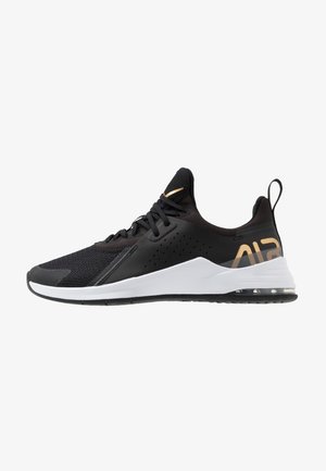 Černá sportovní bota s vrchní části z mřížkového a syntetického materiálu, bílou podešví a zlatými akcenty. Disponuje texturovaným vrškem s ventilačními otvory a tkaničkami.