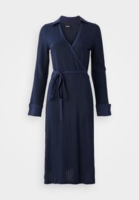 Navy blue wrap dress with vertical ribbed texture, long sleeves, buttoned cuffs, and a tied waist detail.