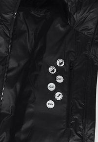 Mustast veekindlast jakkidest sisemus, millel on sile tekstuur, sisaldab mitmeid valgeid tunnuseid, mis näitavad hingavust ja muid omadusi.