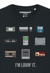 Black t-shirt featuring various retro gaming consoles and controllers in cartoon style, accompanied by the text "I'M LOVIN' IT."