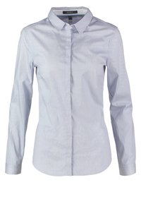 Ljust blå skjorta med lång ärm, vertikala ränder, en spetsig krage och en ficka på vänster sida.