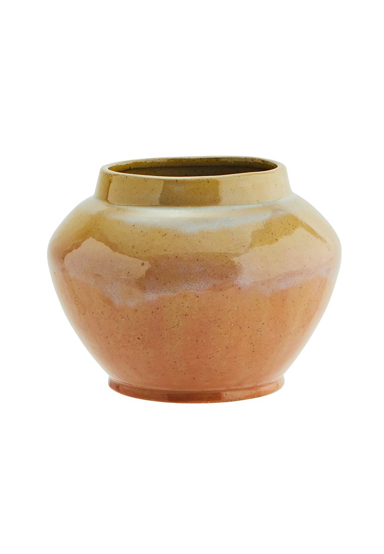 Vaso in ceramica di forma arrotondata, con una superficie lucida in tonalità di beige e arancione chiaro, caratterizzato da una texture liscia e da leggere puntinature.