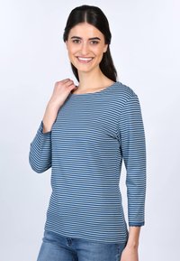 Blau gestreift, langärmliges Hemd mit Schiffs-Ausschnitt und gewellten Bündchen, aus weichem Stoff gefertigt. Kombiniert mit hellen Jeans.