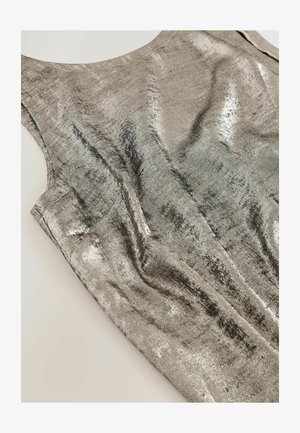 Metāliska bez piedurknēm kleita sudraba krāsā, ar gludu tekstūru un nelielu mirdzumu. Audumam ir vieglas krokas un noapaļota kakla izgriezums.