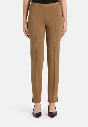 Bruine op maat gemaakte broek met een gladde textuur, met een aansluitend ontwerp, voorpintuck naden en een split aan de zoom. In combinatie met puntige schoenen.