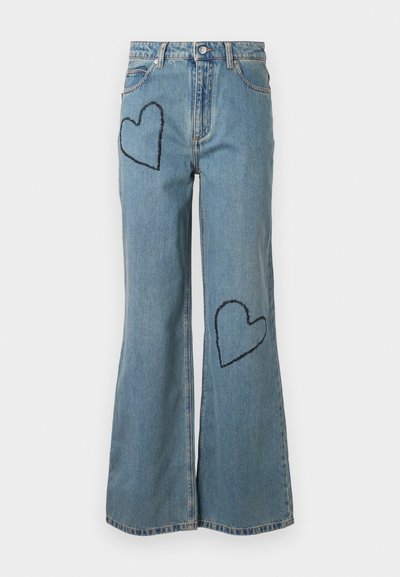 Vaaleansiniset farkut, joissa on liehuvat lahkeet ja edessä kaksi tummansinisestä sydänpatchia. Klassinen viiden taskun muotoilu nappikiinnityksellä.