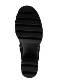 Semelle de chaussure en caoutchouc noir avec un design nervuré, présentant une finition lisse et plusieurs rainures horizontales pour l'adhérence. Bout rond, forme élégante.