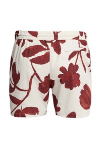 Hvide teksturerede shorts med elastisk taljebånd, med stort mørkerødt blomsterprint og en enkelt baglomme på højre side.