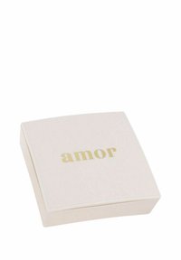 Fyrkantig blushask i slät material med "amor" i guldtext på locket, med en mjuk rosa bakgrund.