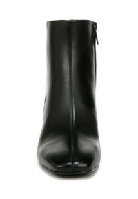 Stivale alla caviglia in pelle nera con texture liscia, punta arrotondata e chiusura con zip laterale. Presenta un design minimalista e una silhouette elegante.