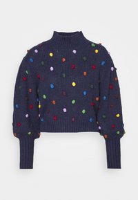 Pull en maille bleu marine avec un col montant et une coupe courte. Il présente des pompons multicolores répartis sur toute la surface et des poignets côtelés.