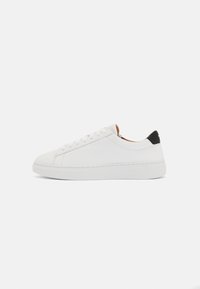Hvide lædersneakers med rundt tåparti, flad sål og tonalt syning. Har en sort hælklap og simpel snørebåndslukning.