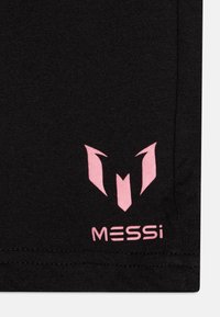 Černá tkanina s růžovým logem designem a stylizovaným písmenem "M" nad textem "MESSi." Hladká textura s přiléhavým tvarem.