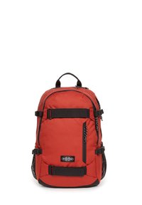 Mochila roja hecha de tela duradera, con acentos negros, correas ajustables, un bolsillo frontal y bolsillos laterales de malla para almacenamiento.