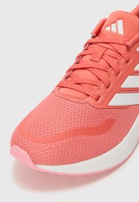 Pink mesh athletic shoe featuring a textured surface, white accents, and a lightweight design with a curved sole labeled "CLOUDFOAM."