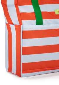 Borsa in tessuto a righe arancioni e bianche con manico verde e una tasca esterna visibile sul lato.