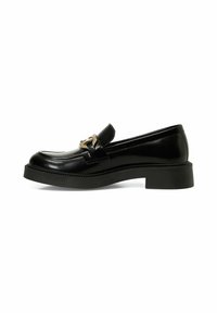 Mocassin en cuir verni noir avec un faible talon carré et un accent en métal doré décoratif. Texture lisse et design épuré.
