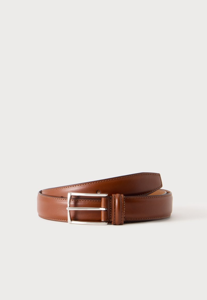 Ceinture en cuir marron avec boucle rectangulaire argentée roulée sur un fond blanc.