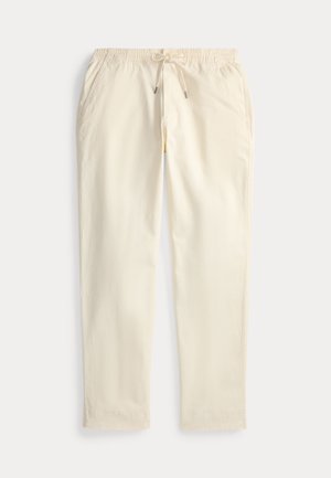 Pantalones de algodón color beige claro con cinturilla elástica, cordón ajustable, bolsillos laterales y un corte relajado. Textura suave, diseño versátil.