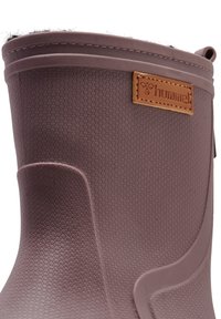 Stivale di gomma marrone con superficie testurizzata, dotato di foderatura in pelliccia sintetica nella parte superiore e di un'etichetta in pelle con il nome del marchio "Hummel."