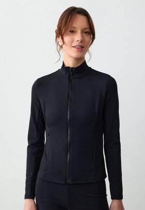 Schwarze Zip-Jacke aus einem glatten, dehnbaren Material. Sie verfügt über einen hohen Kragen, lange Ärmel und seitliche Taschen. Fitting-Design.